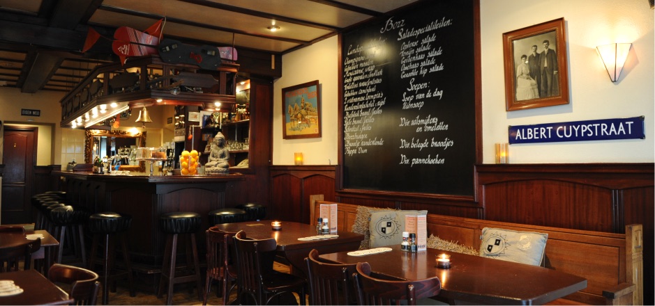 Het bruine interieur van Bozz met bar, krijtbord en houten lambrisering